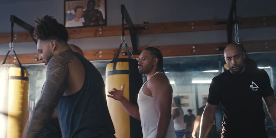 Group of men in a gym high five and hug after a workout