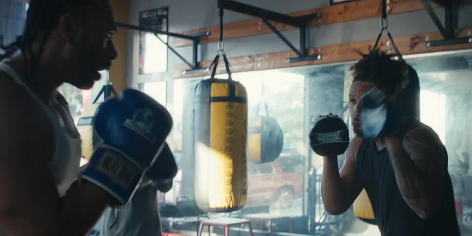 Two men are sparring in the gym