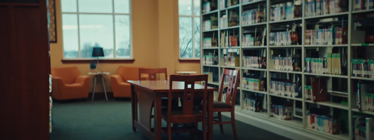Sitting areas occupy the space next to full bookshelves in a public library on a winter day