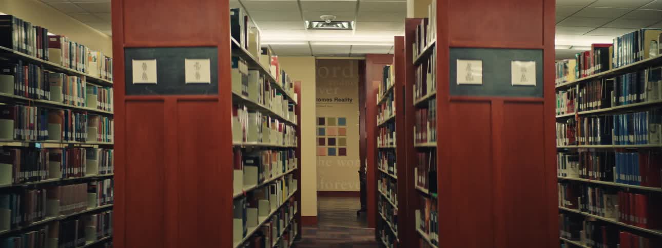 Rows and rows of books on shelves inside of a large library