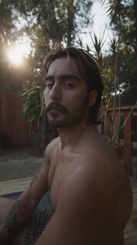 A man gives a sad look while sitting in a backyard