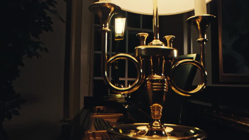 Interior design with a lamp with lit candles in a room at night