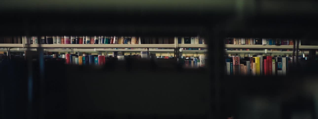 Shelves full of books in a library are slowly scanned from right to left