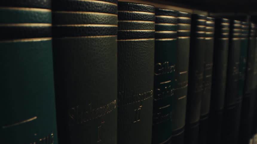 A shelf of hardcover books in green colors