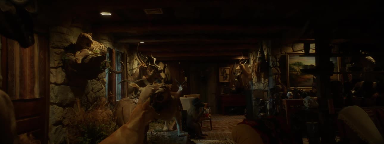 A large hunters room filled with stuffed animals as trophies along with artwork and furniture