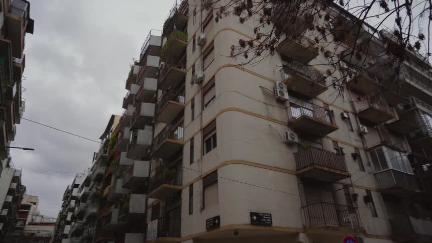 Several apartment buildings crowd a city street