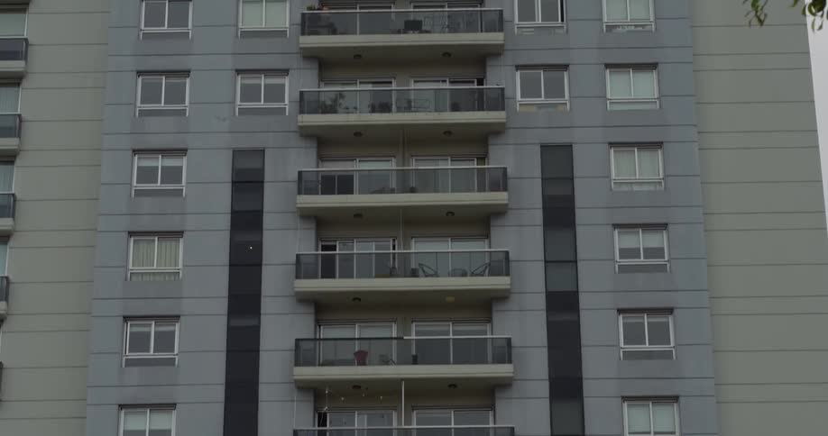 Apartments share a balcony platform in a midrise apartment building