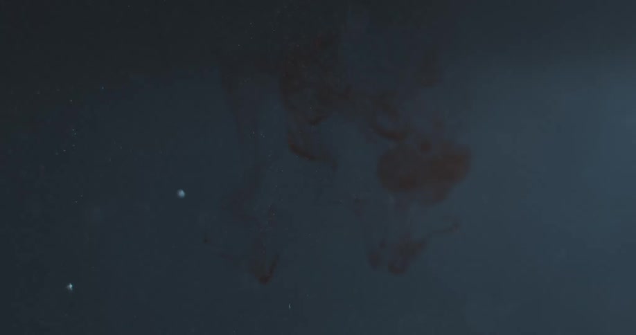 A red fluid falling underwater and several particles around