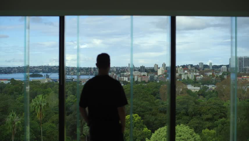 A clip of a person looking outdoor from the window