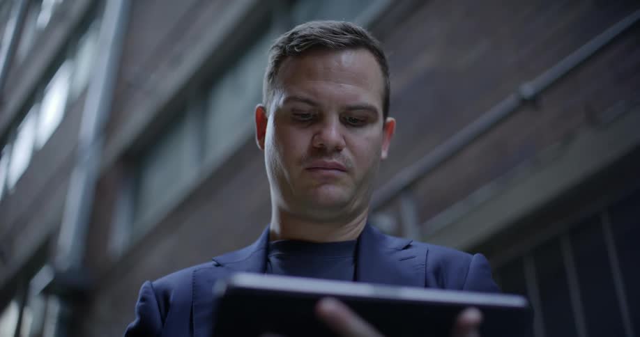 A clip of a man busy operating his tablet