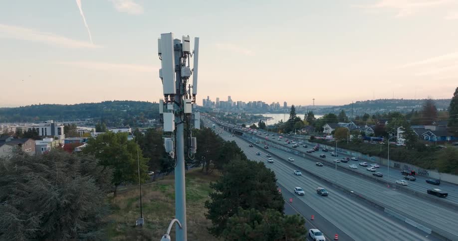 Soft light wraps around a 5G small cell in the Seattle U district during the evening commute