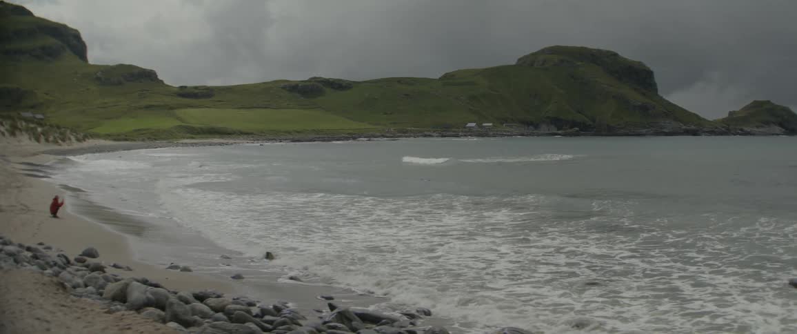 Landscape of a beach on a cloudy day with a person in the background