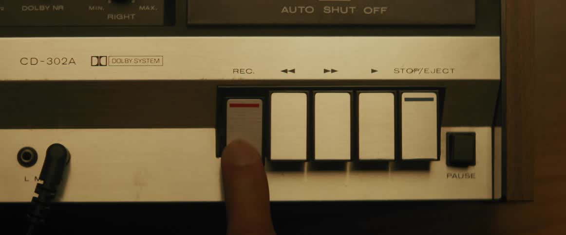 A person presses record on a tape recorder