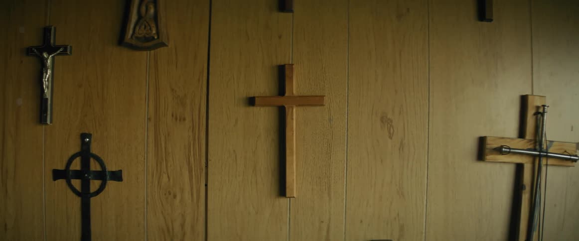 A wooden wall adorned with various religious crosses and symbols