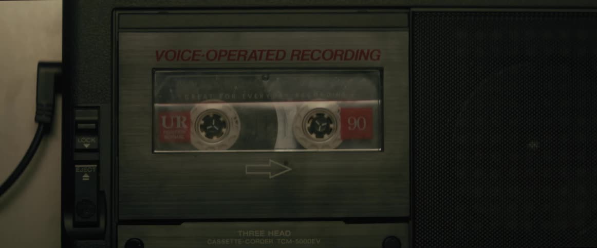 Person inserts a music tape into a cassette player