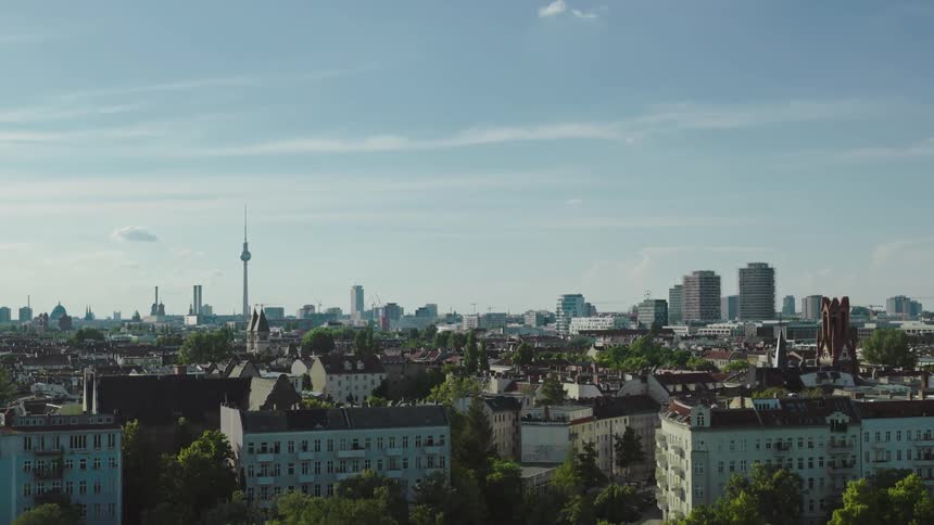 A large city with a spire and suburbs sprawls to the horizon