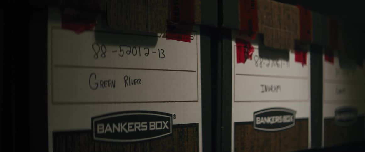 Row of dark file boxes with white labels and tape