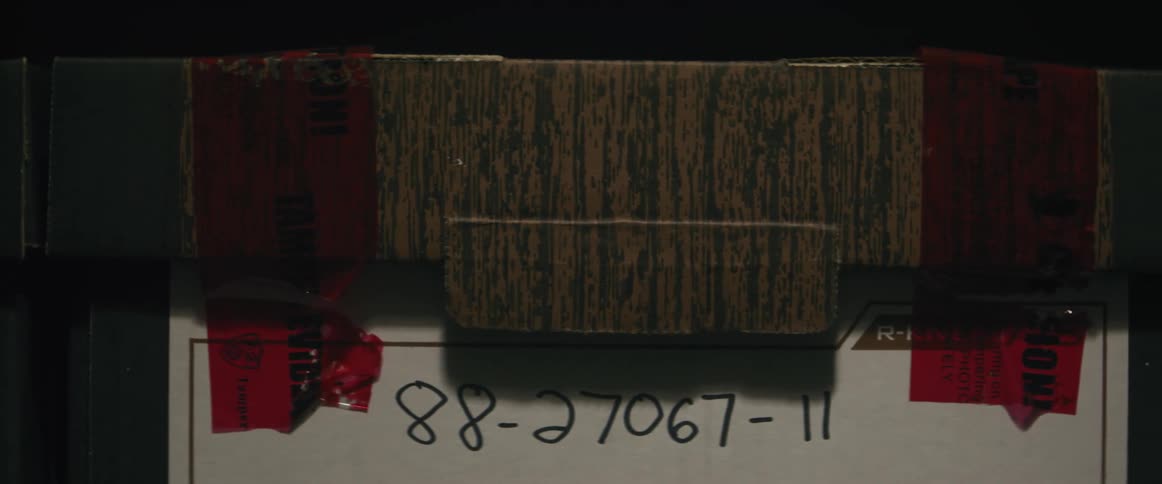 file boxes with red ribbons and numbers written on white paper in front of them