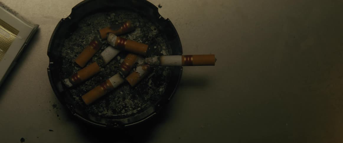A cigarette is burning in the ashtray