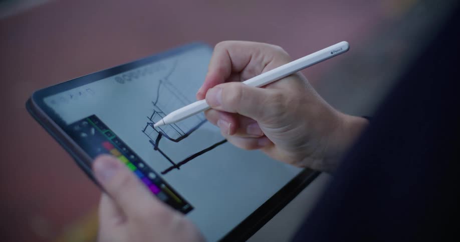 A man in a suit draws lines on a diagram displayed on a tablet