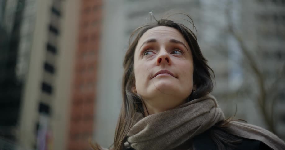 Portrait of a woman with a gray scarf looking around in a metropolis