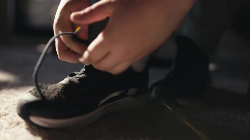 A clip of a person putting on a shoe
