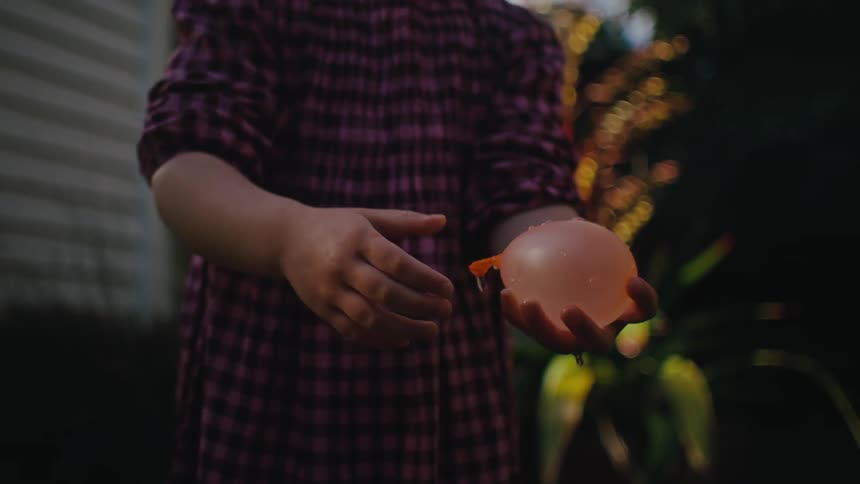 Little girl holding a water balloon