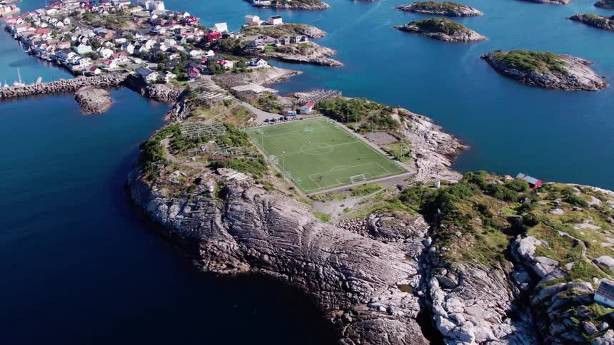 An aerial view of a small island with a soccer field in the center