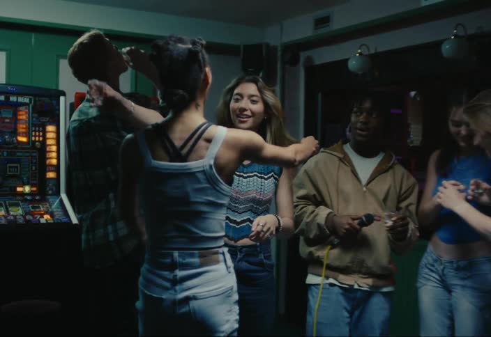 Group of friends in a room with two women greeting each other