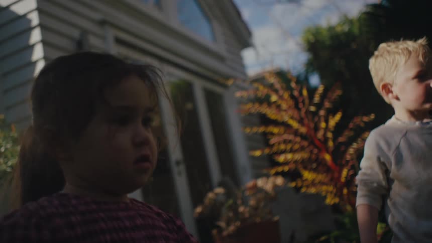 Little girl throwing a ball while in her backyard