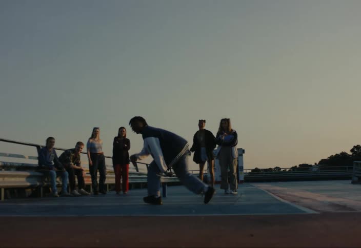 Teenagers in an outdoor setting having fun with one of them dancing