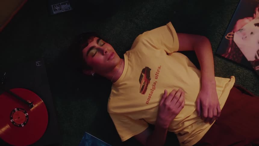 Person lying next to a playing vinyl record