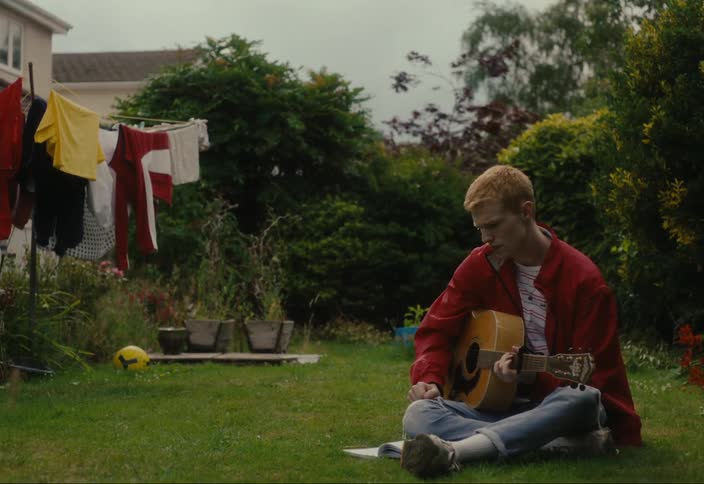 Man plays guitar sitting on the grass