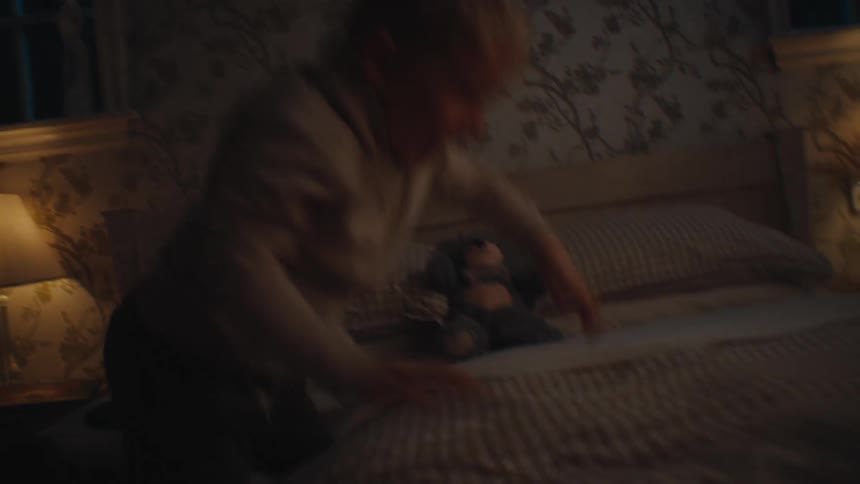 Little boy on the bed in a room playing