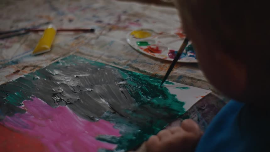 A young boy paints a picture