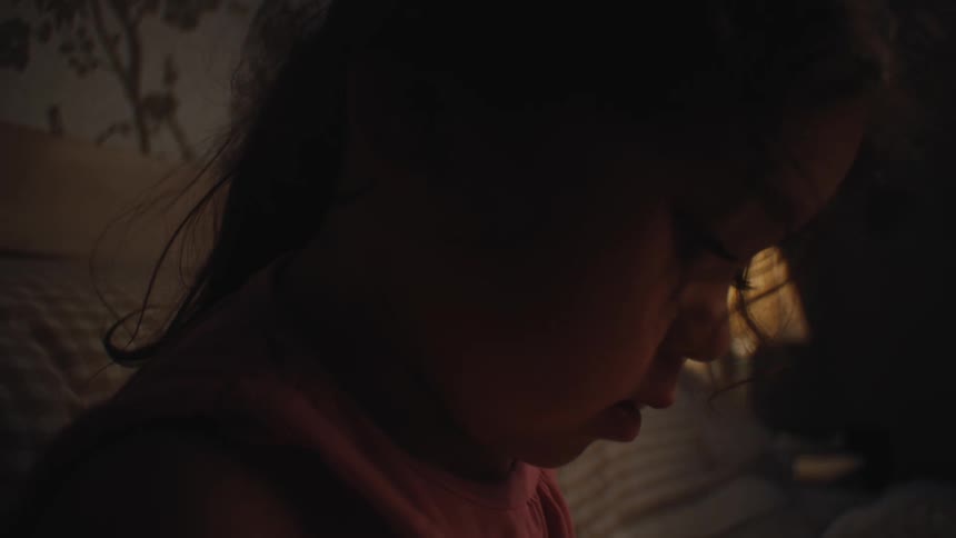 A young girl sits in bed