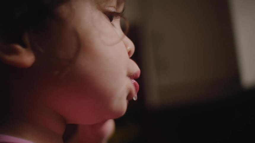 Closeup of a girls face while brushing her teeth