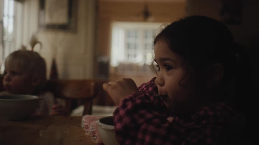 Two little girls sitting at the table eating