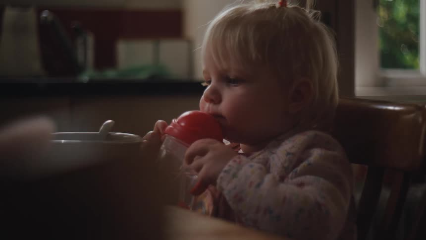 A young girl sips on her cup