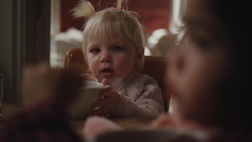 Two little girls sitting at the table eating
