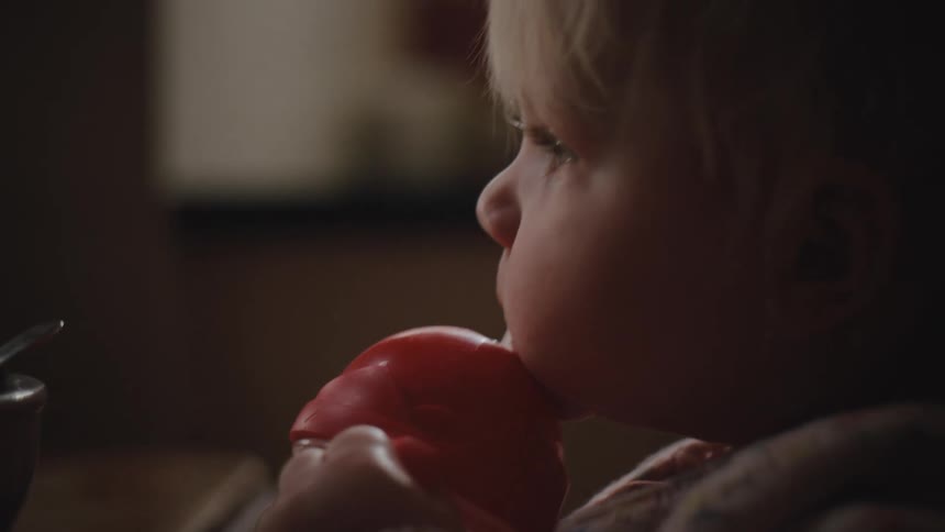 A closeup of a child drinking from a red sippy cup