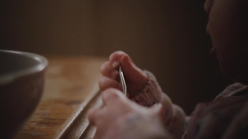 Closeup of a babys hands holding a spoon