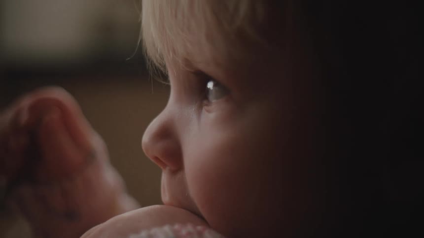 Closeup of a babys face while eating food at home