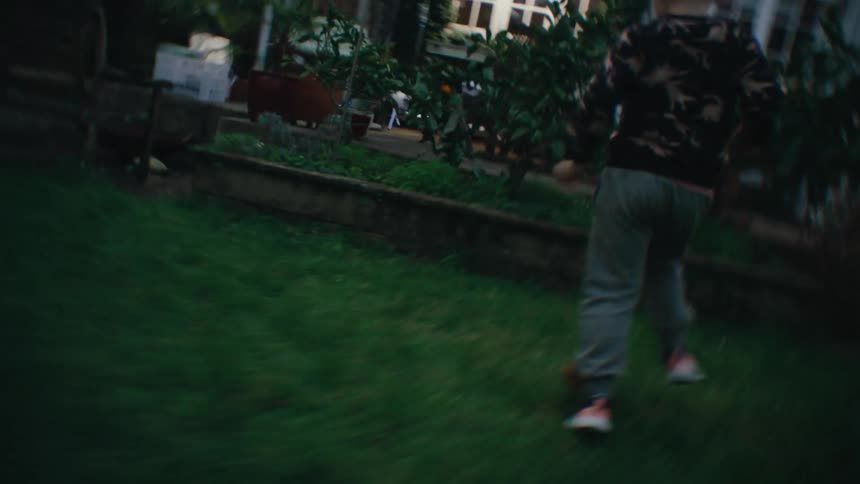 Little boy running through the grassy yard