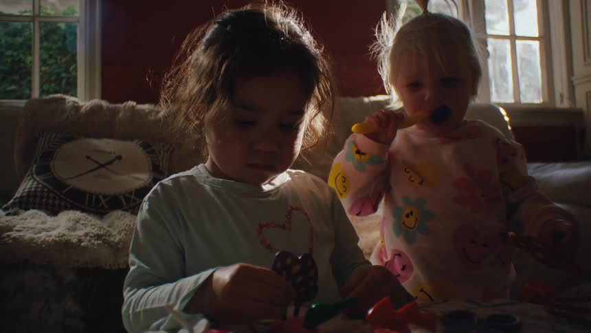 Three small children in the living room playing