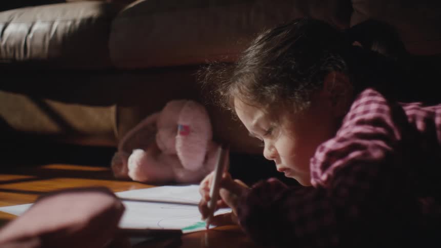 Little girl lying on the floor drawing