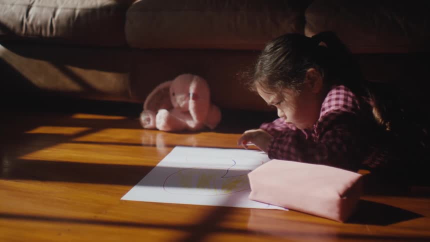 Little girl lying on wooden floor drawn on white cardboard