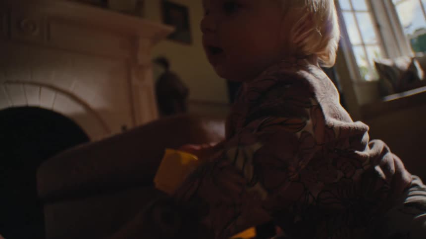 Little girl sitting in the living room playing with different toys