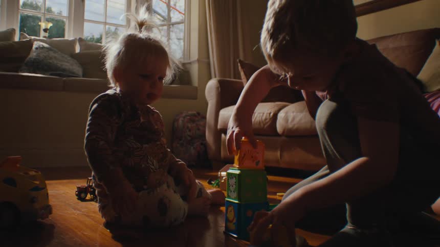 Three small children from different cities playing in the living room