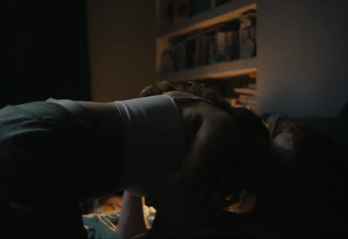 A man and a woman are lying in a bed and they are kissing romantically
